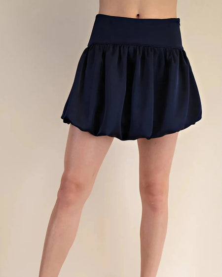 Navy blue skirt worn by a person on a beige background