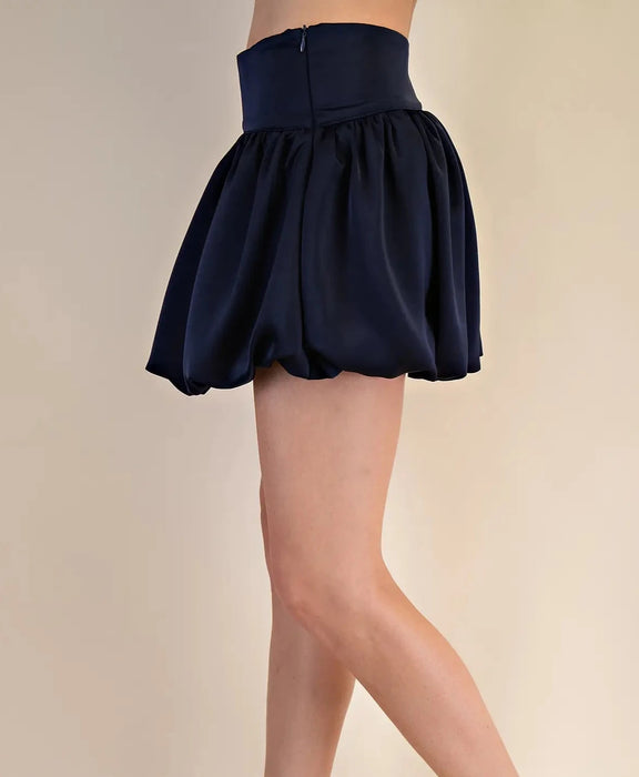 Navy blue skirt worn by a person on a beige background